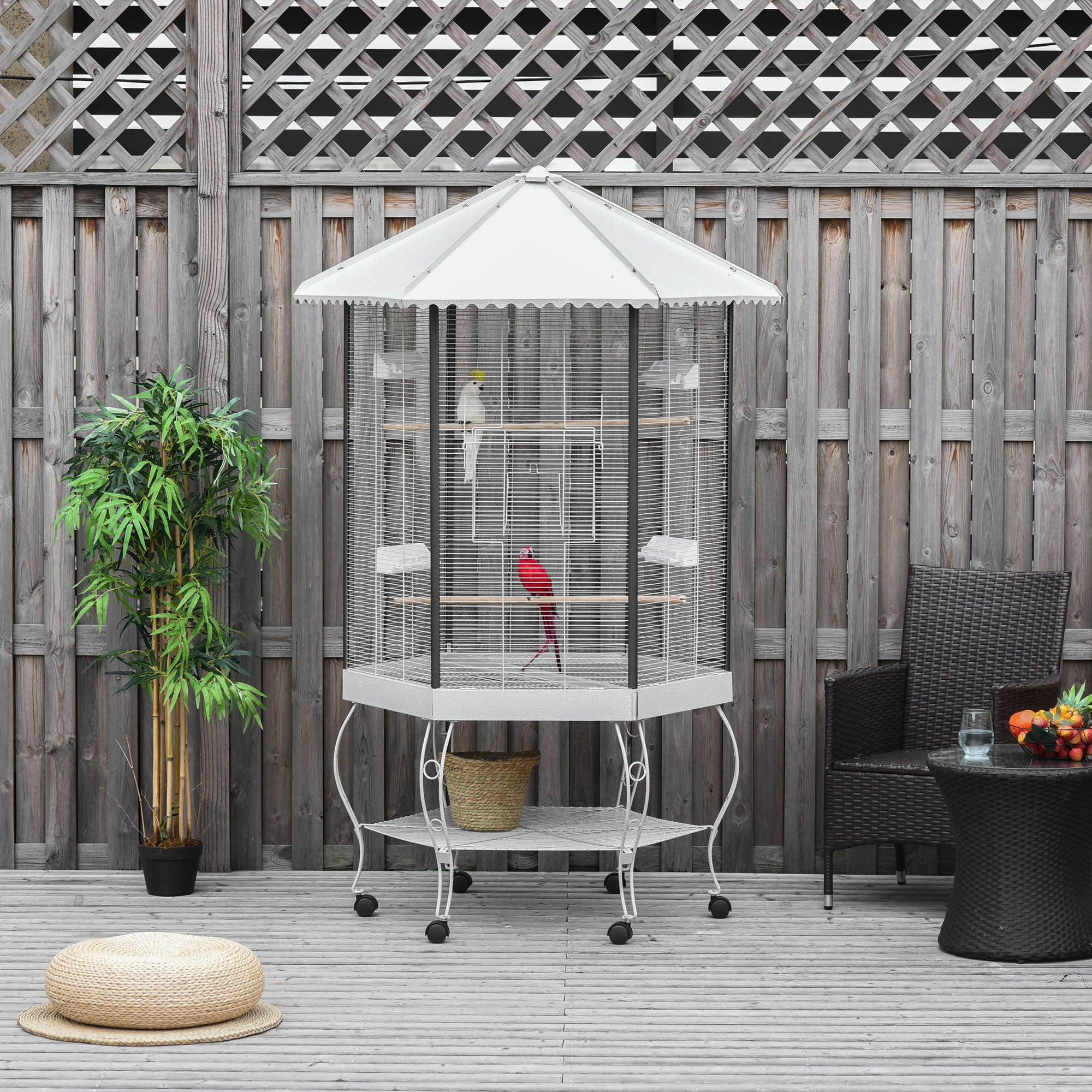 Bird cage with umbrella on a wooden deck with plants and furniture
